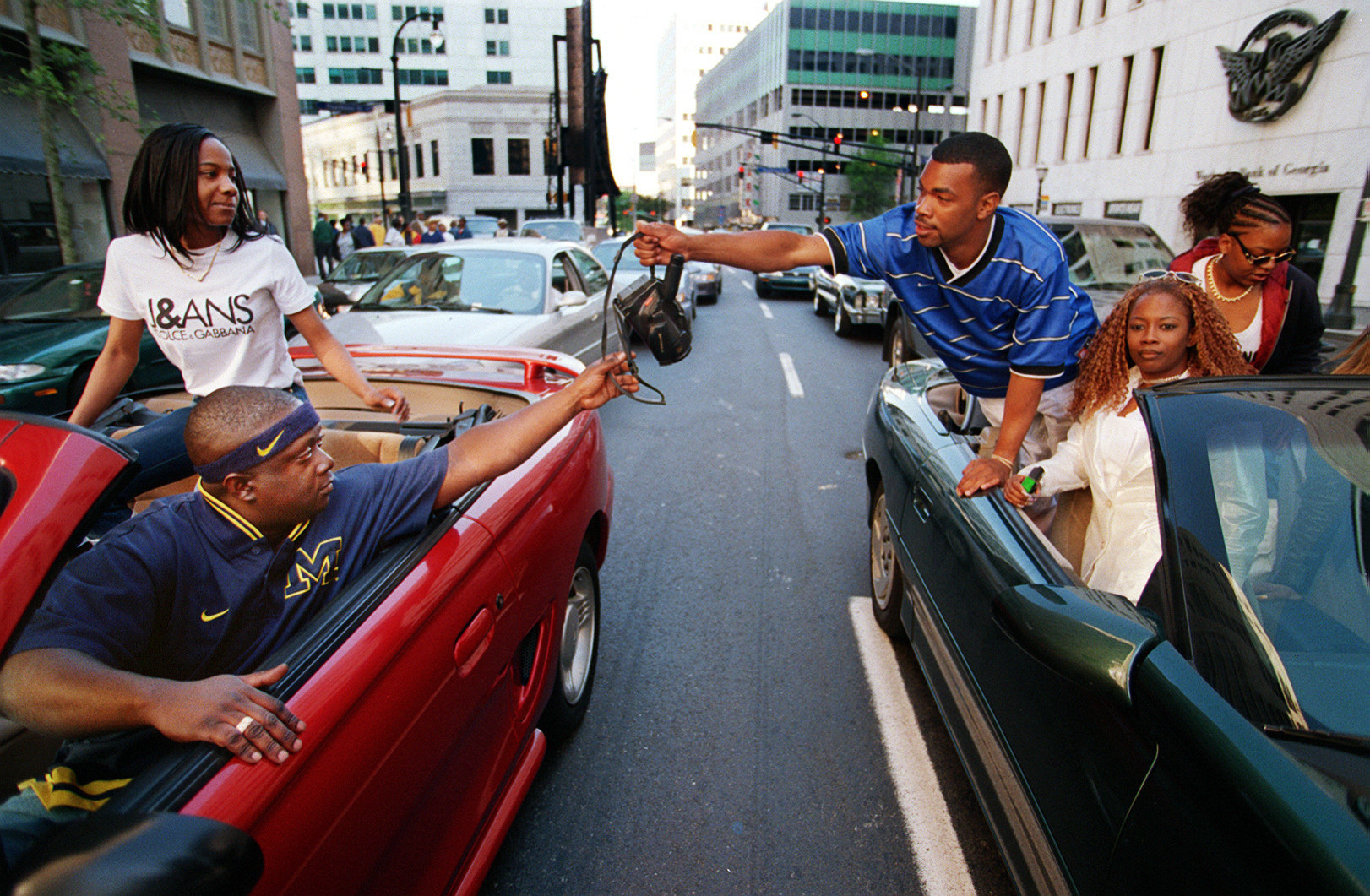 two groups of people in cars exchange a camera in stopped traffic in atlanta 