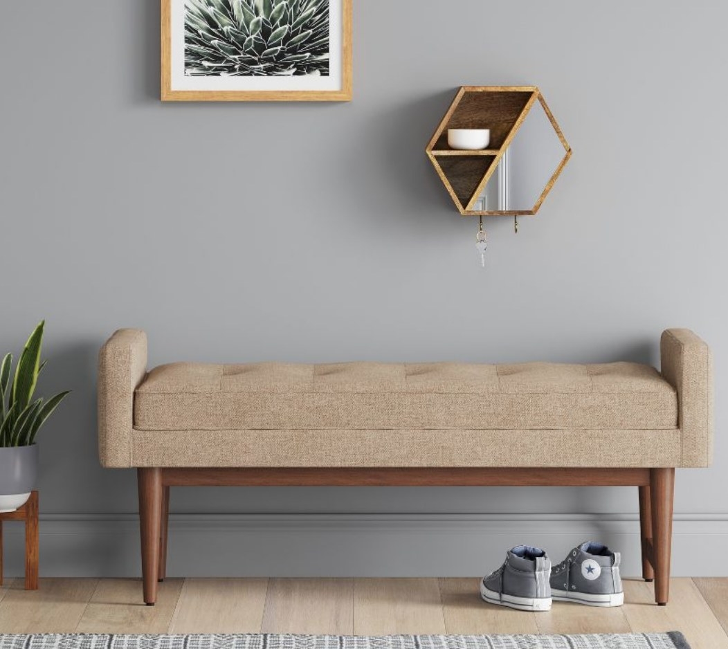 A tan mid century modern bench in an entryway