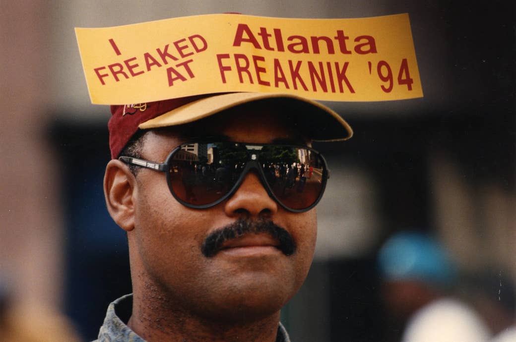 a man in sunglasses and a hat has a sticker pinned to the hat that reads i freaked at atlanta freaknik 94