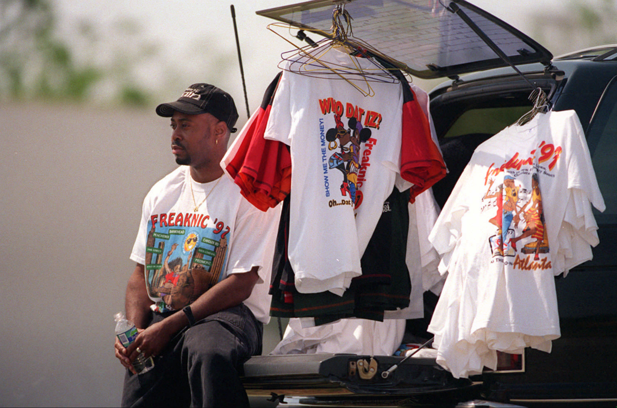 A man selling t shirts out of the back of his car for Freaknik 97 