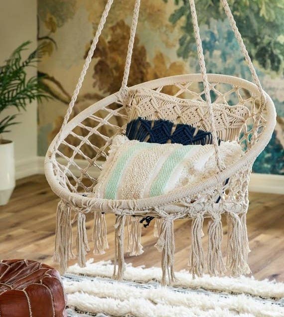 A beige macrame hanging hammock in a living room