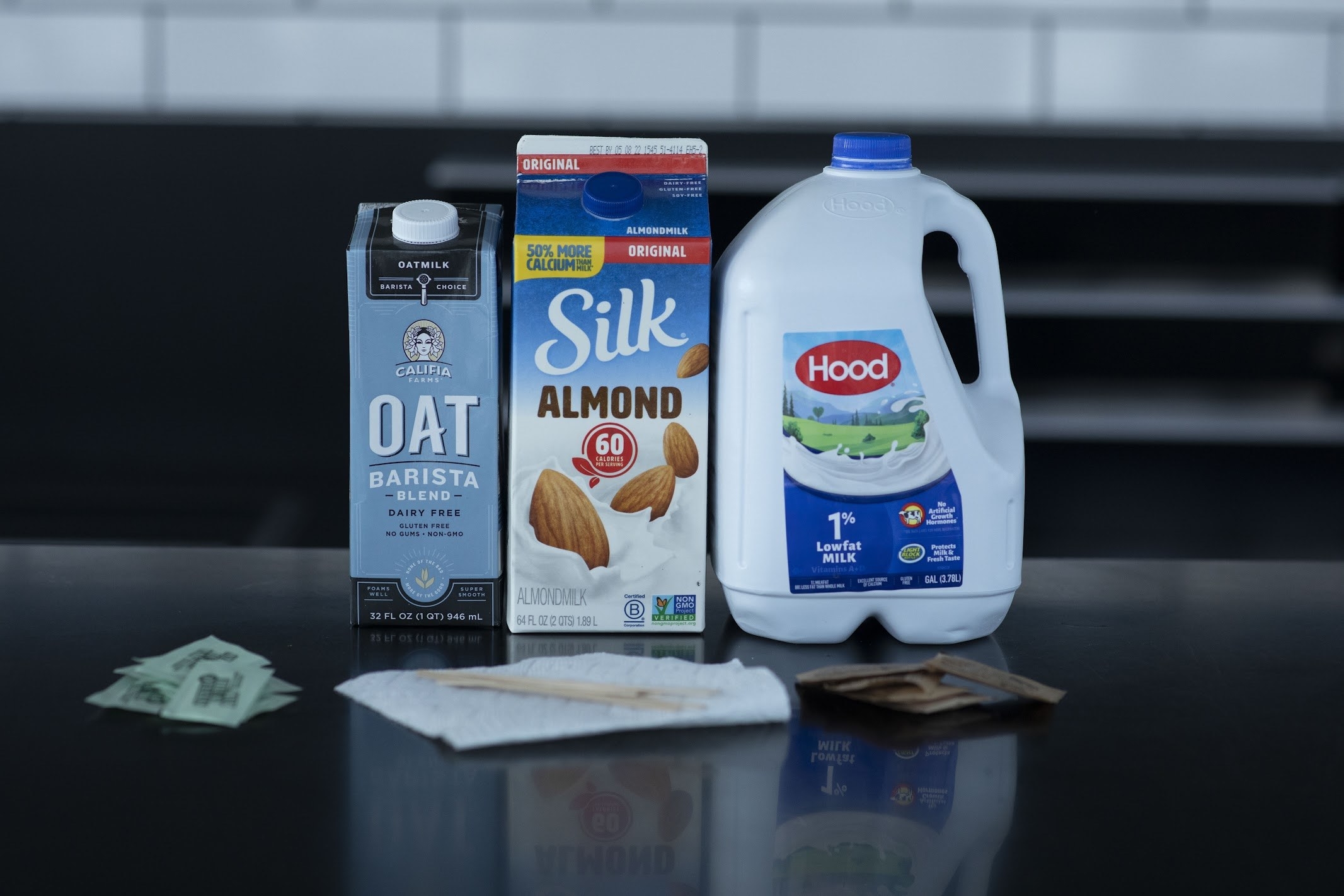 Cartons of oat milk and almond milk, a jug of 1% low-fat milk, and packages of other milk substitutes