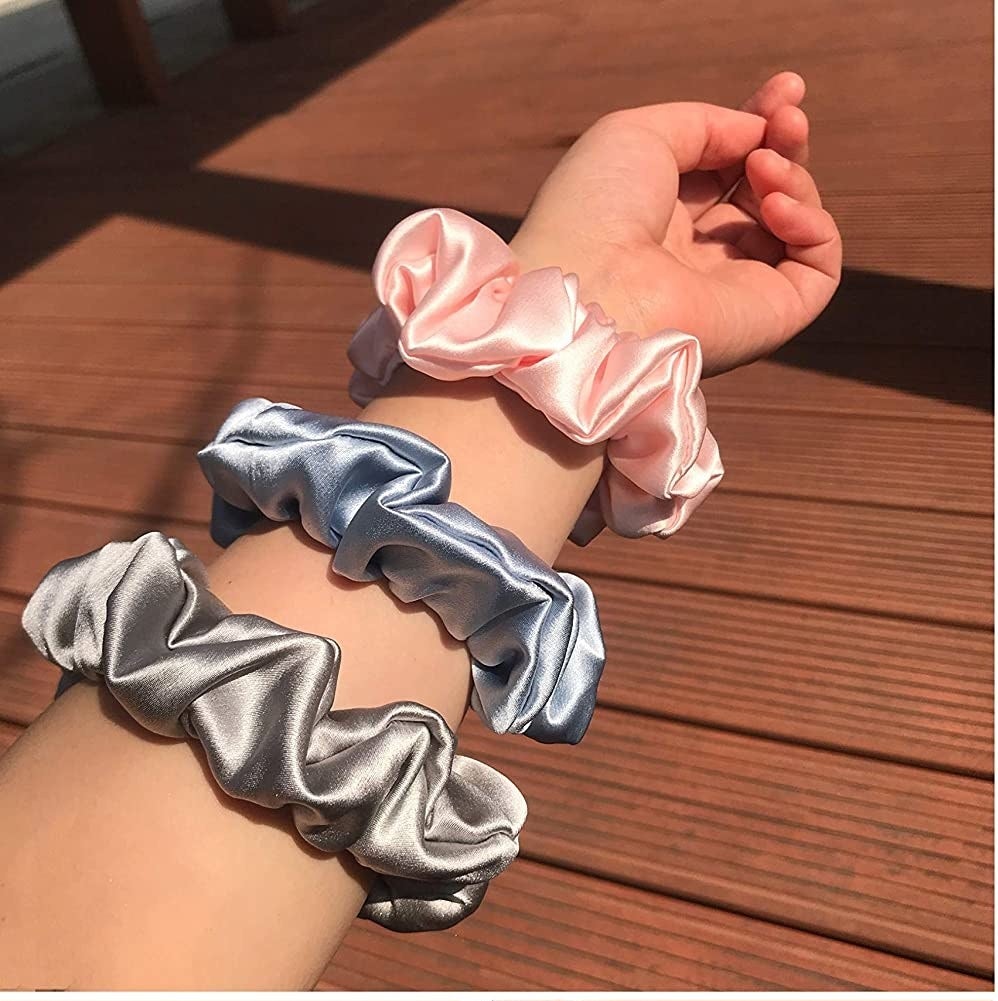A person with three of the scrunchies on their arm outside