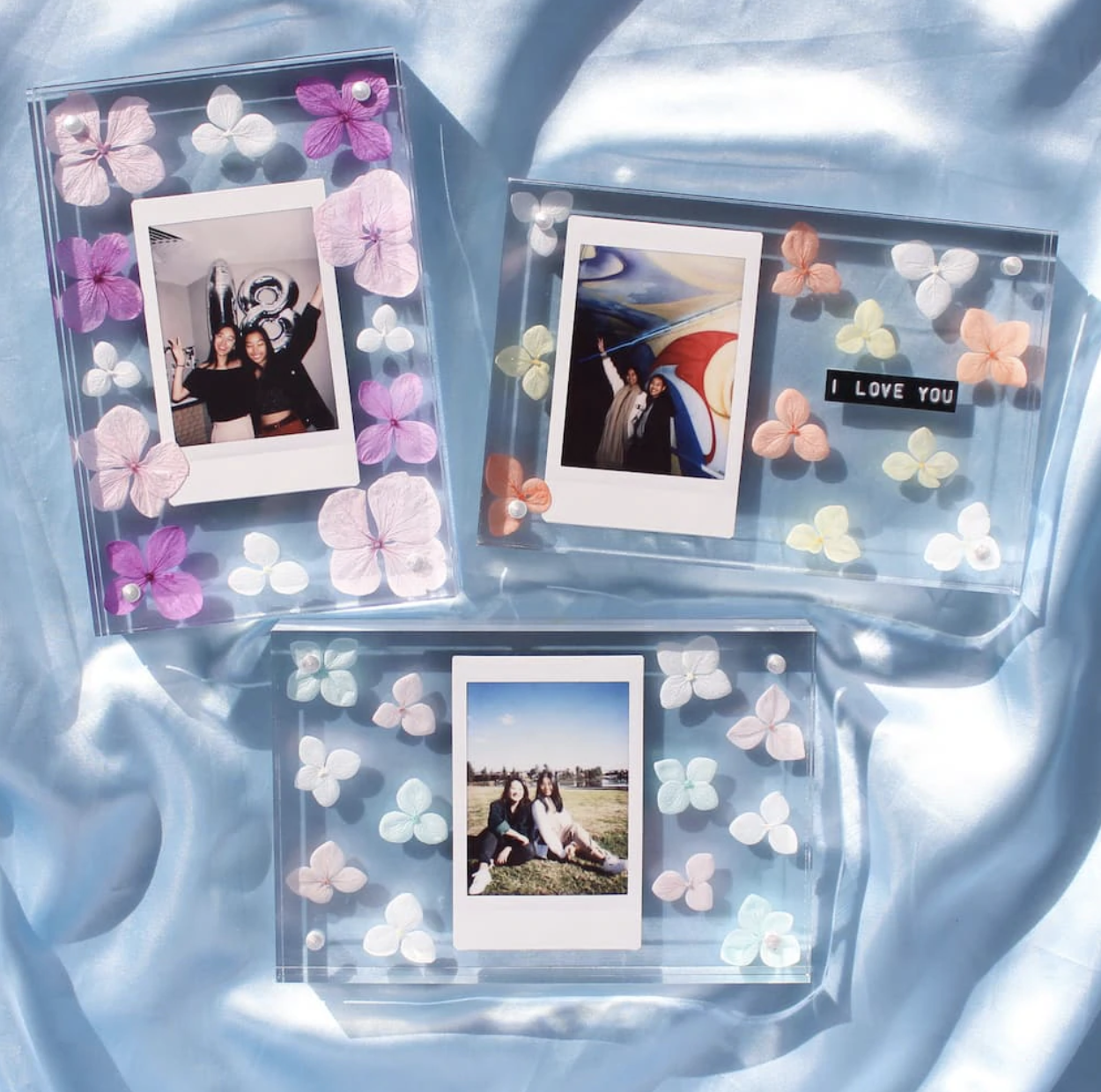 Three personalized picture frames with various flower decorations