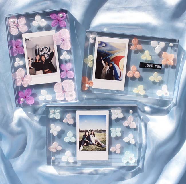 Three personalized picture frames with various flower decorations