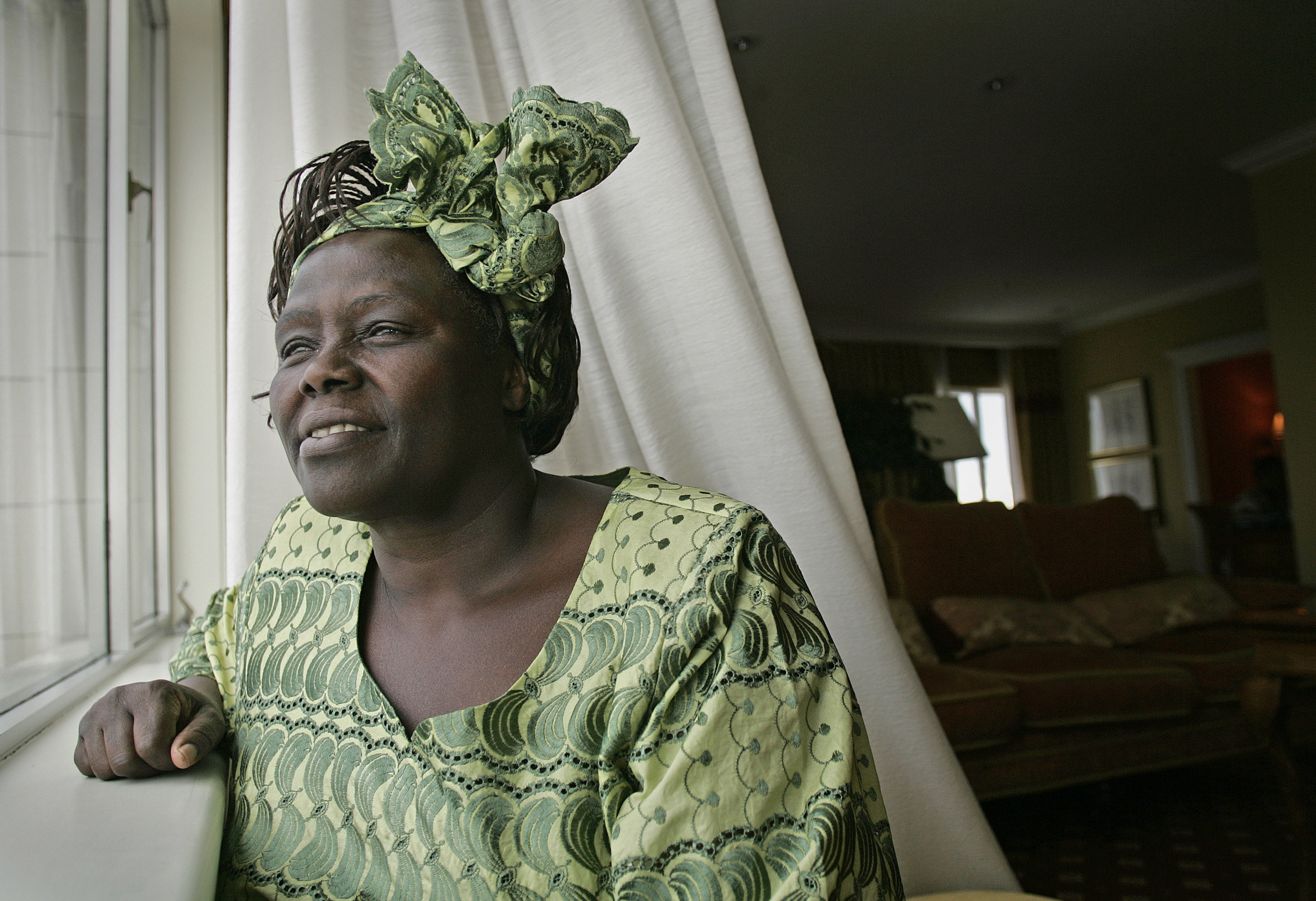 Wangari Maathai smiling as she looks out of a window