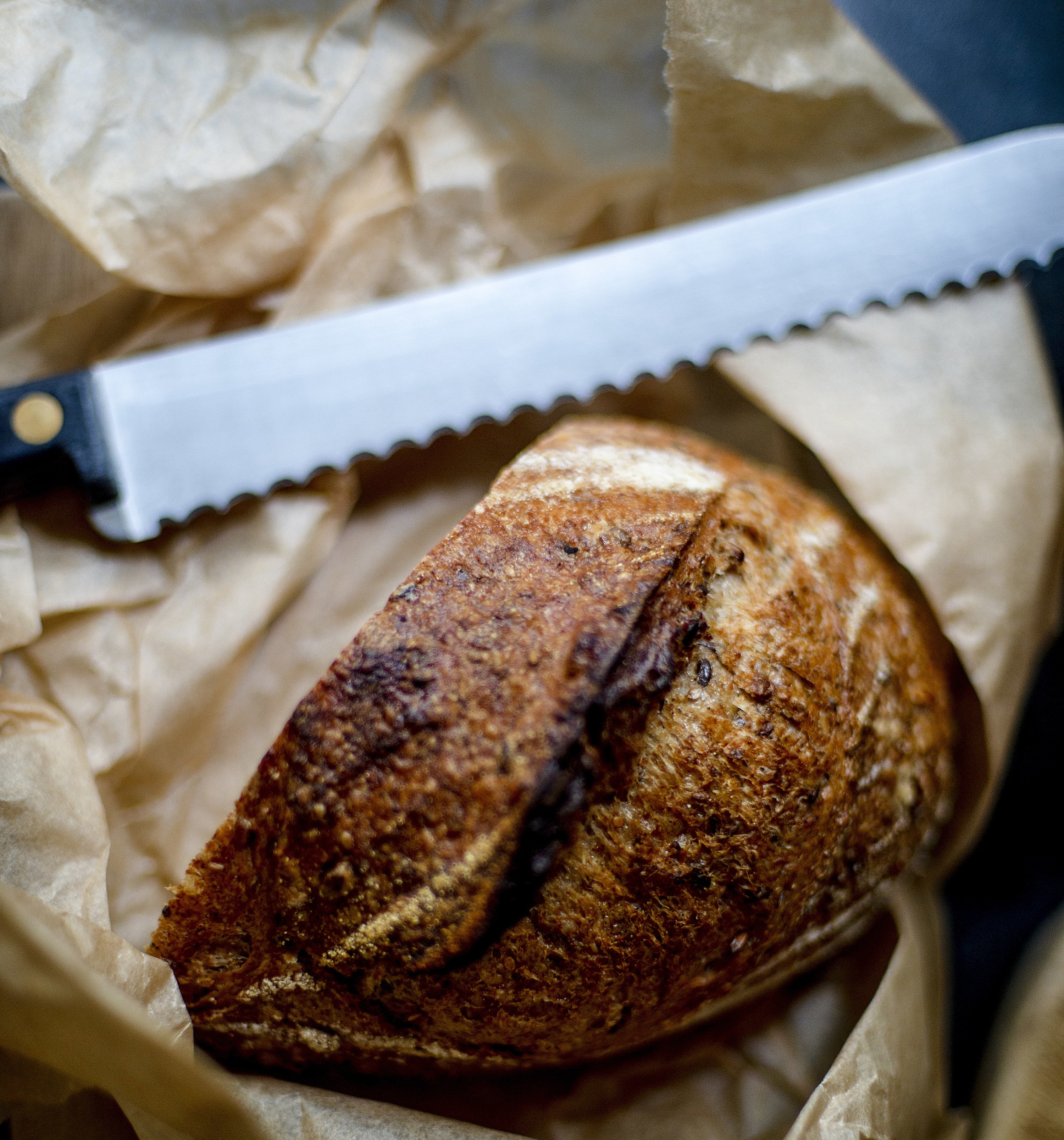 bread knife laid down next to a loaf of sliced bread