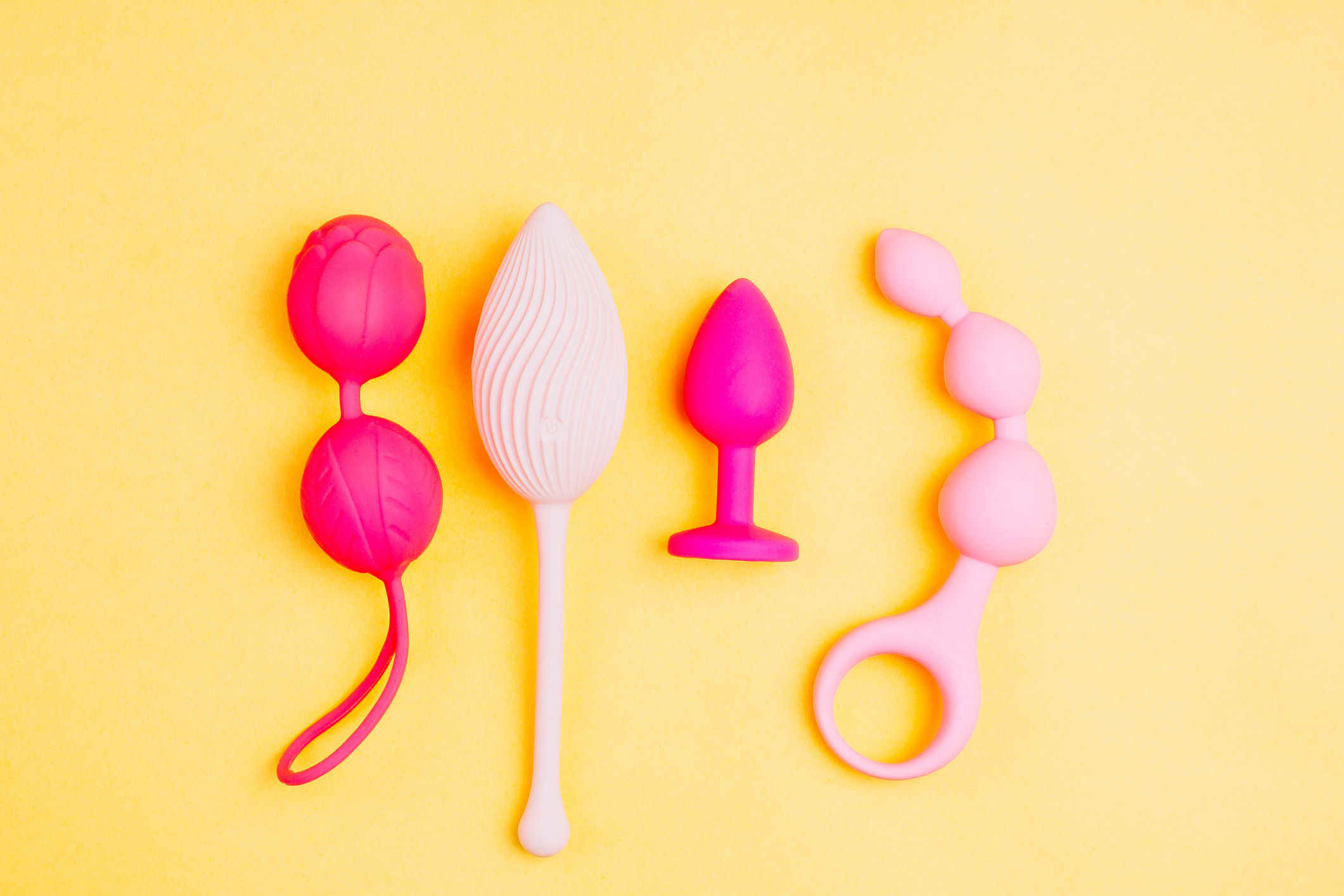 Stock image of pink sex toys on a yellow background