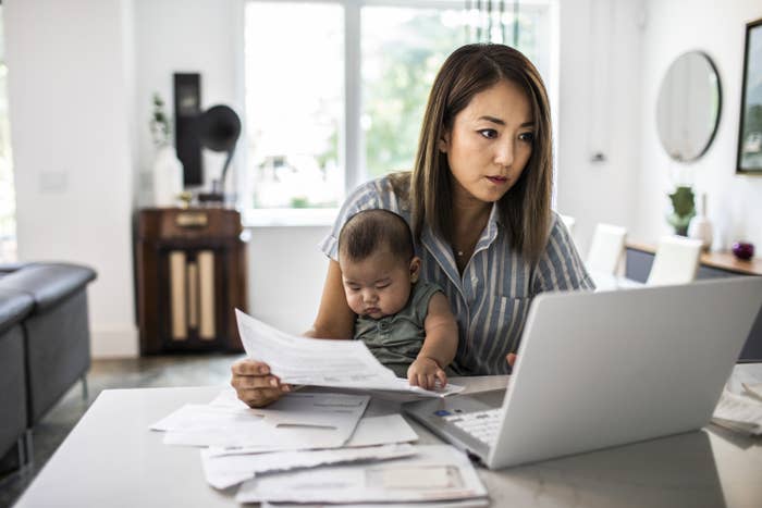 Woman holding a baby while working from home