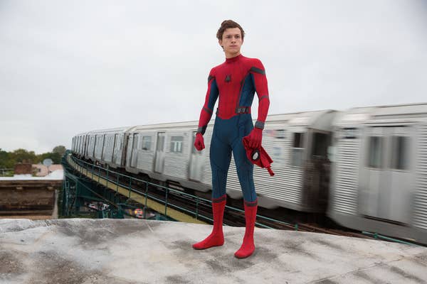 Homem-Aranha parado ao lado de um trem do metrô