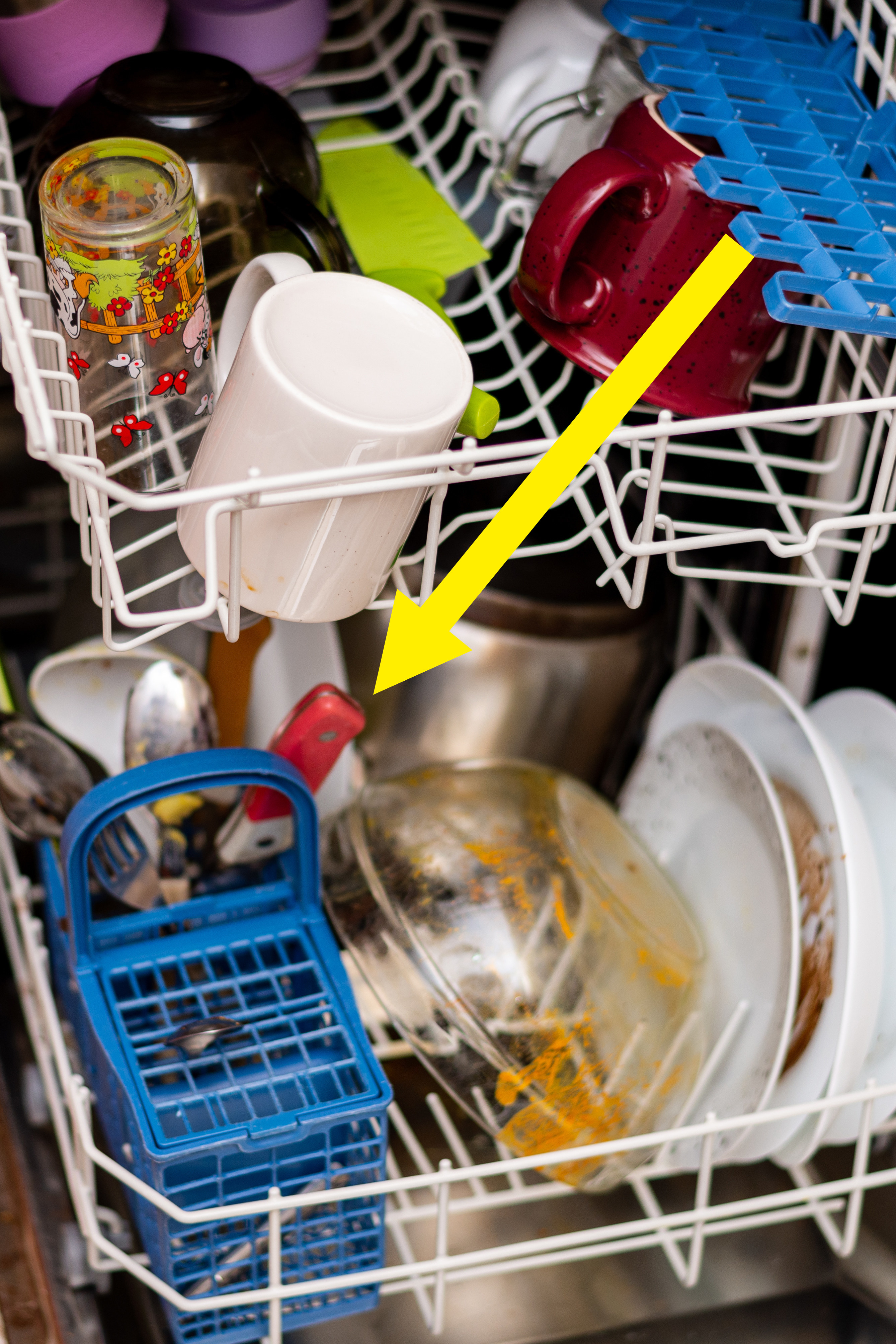 Arrow pointing to a red knife in a loaded dishwasher