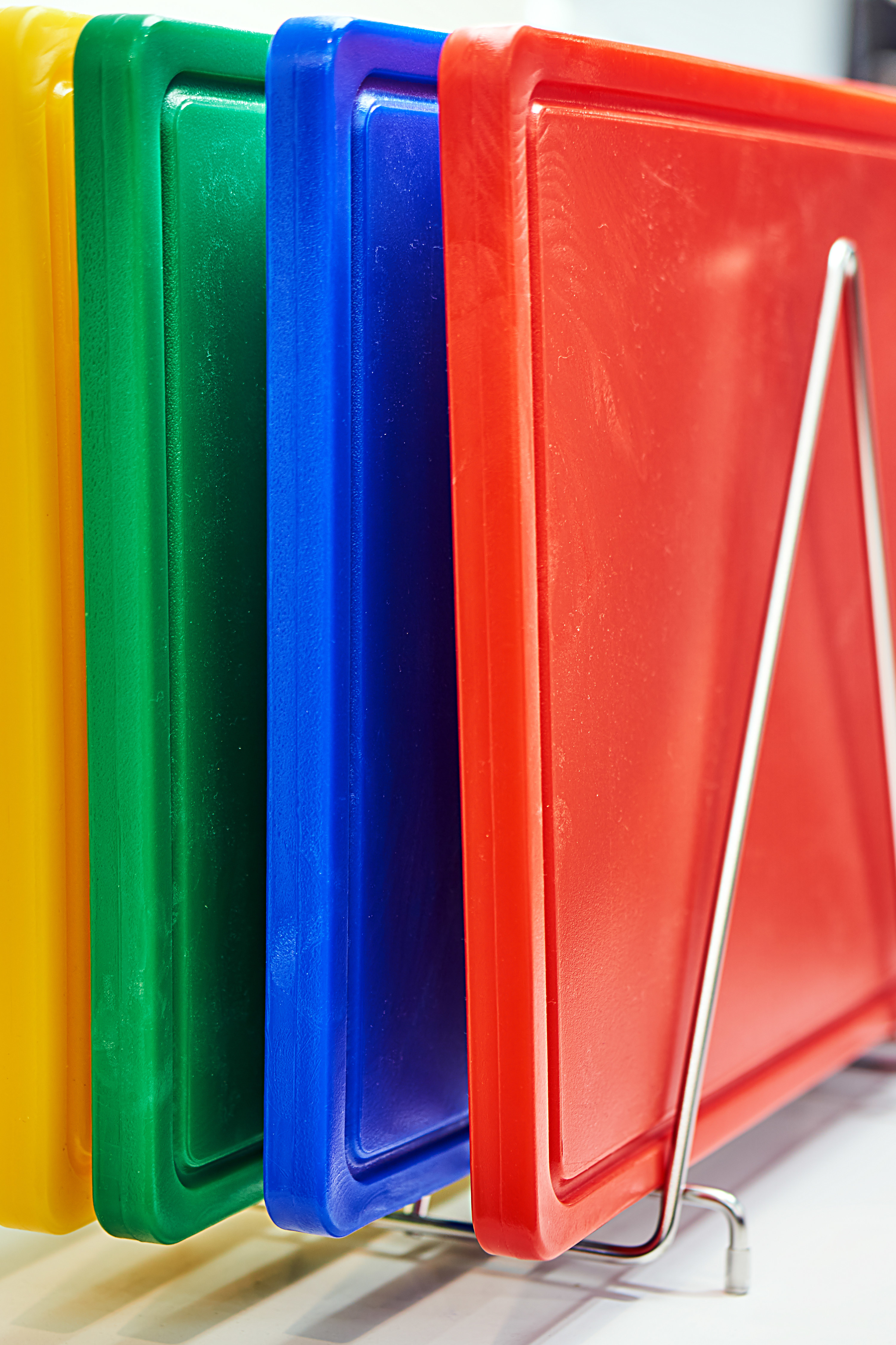 color-coded cutting boards on a rack