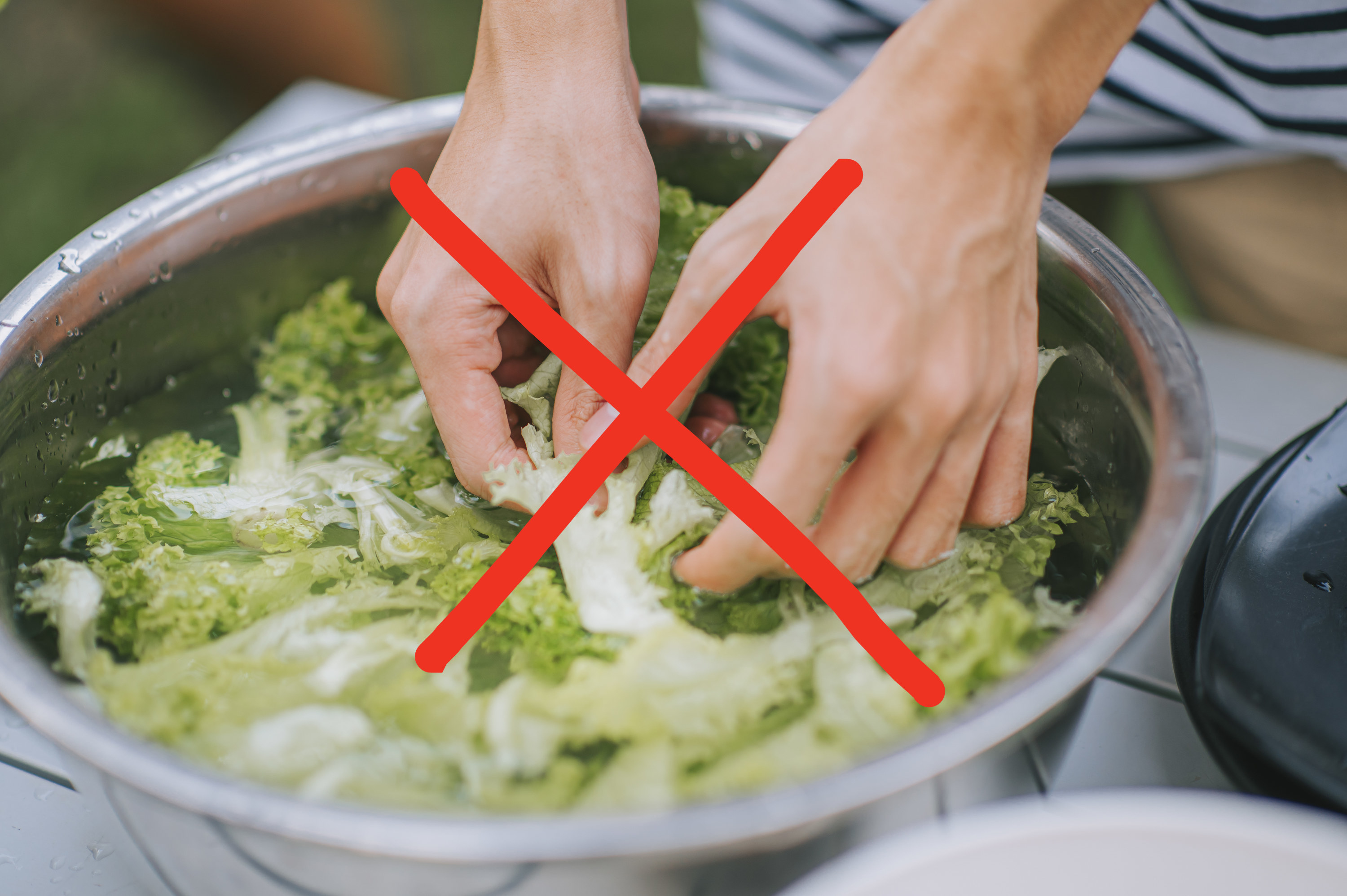 An X over a picture of a person washing broccoli in a bowl of water