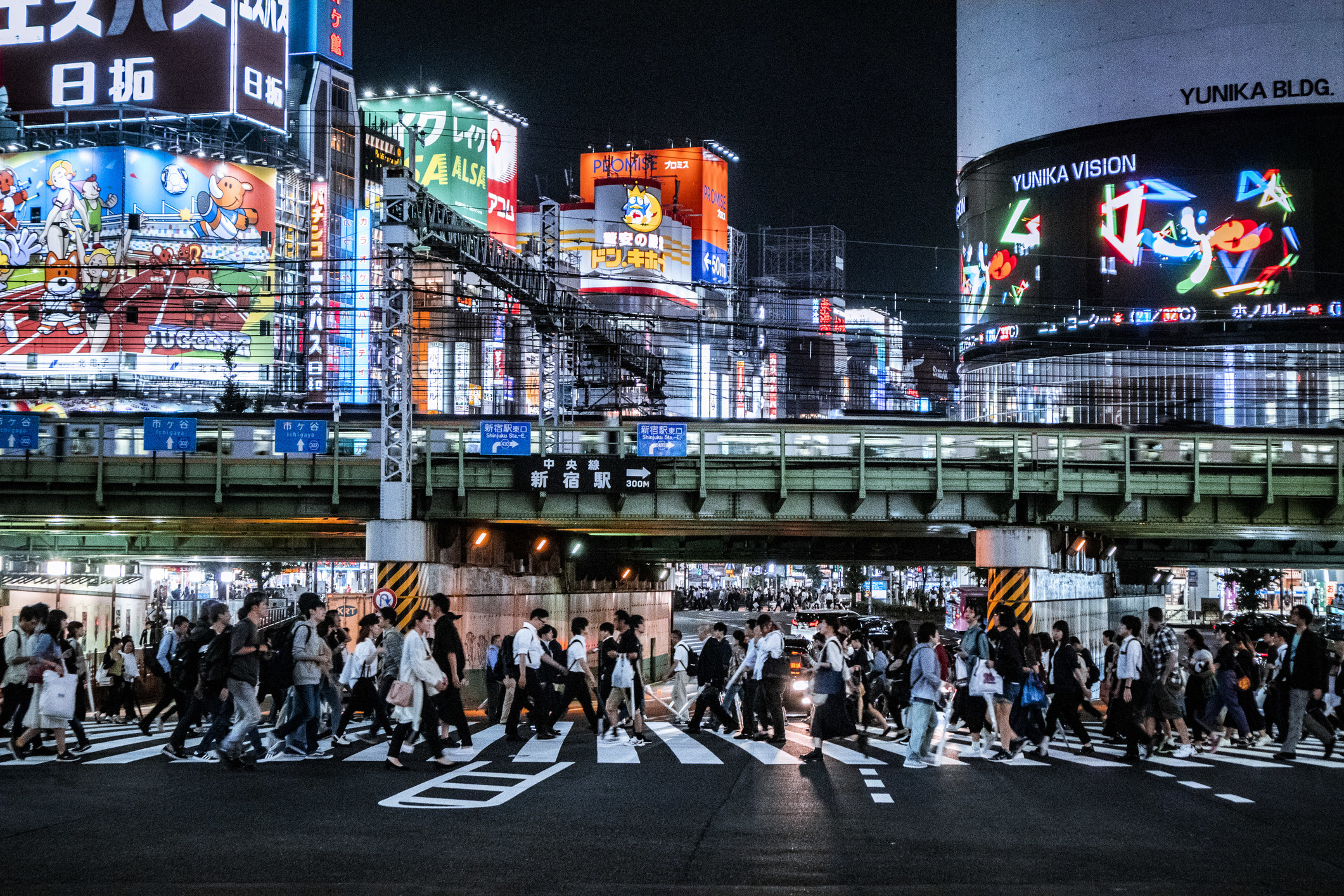 A clean street in Tokyo with lots of neon lights and signs