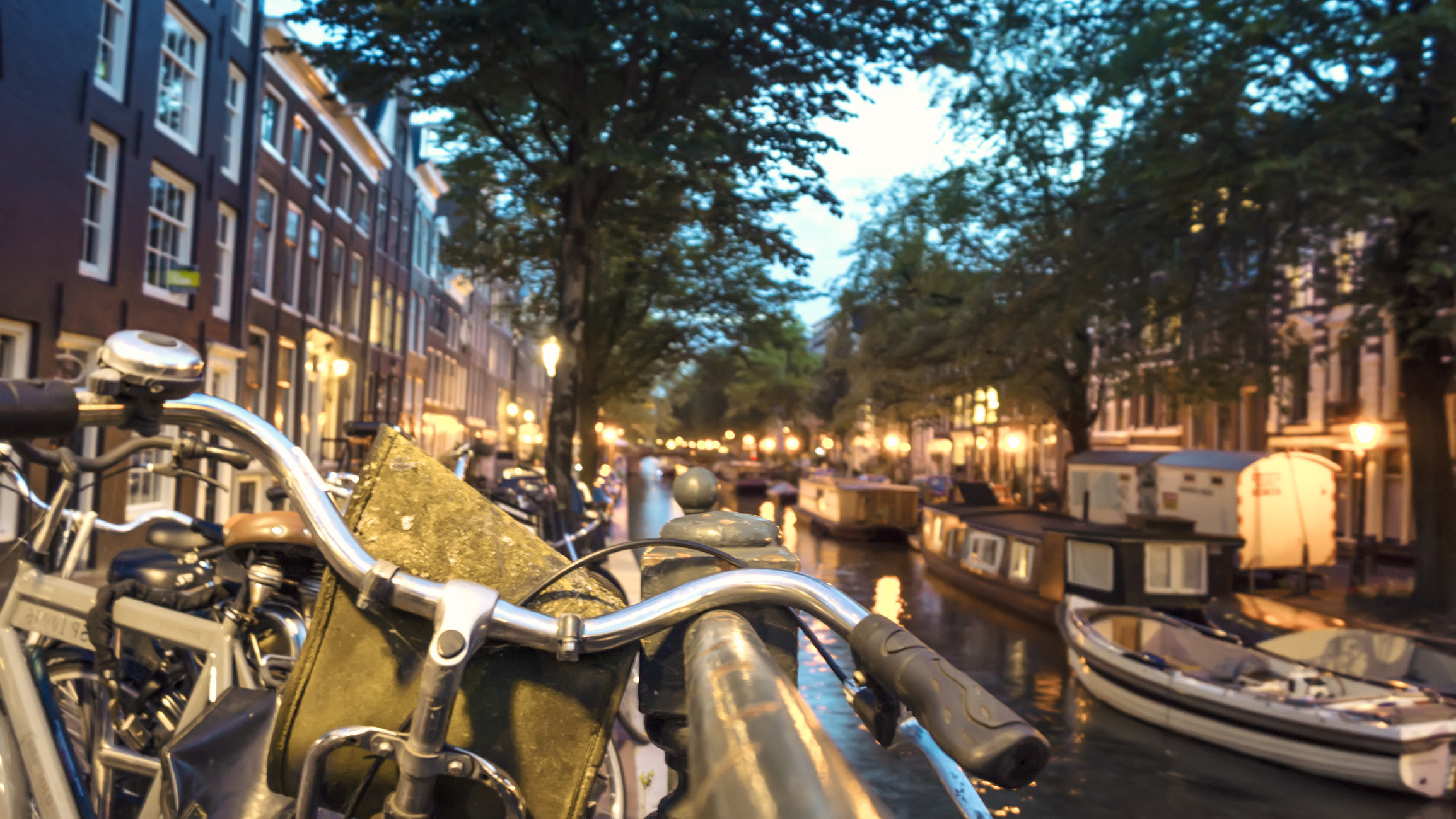 The handlebars of bikes by a canal