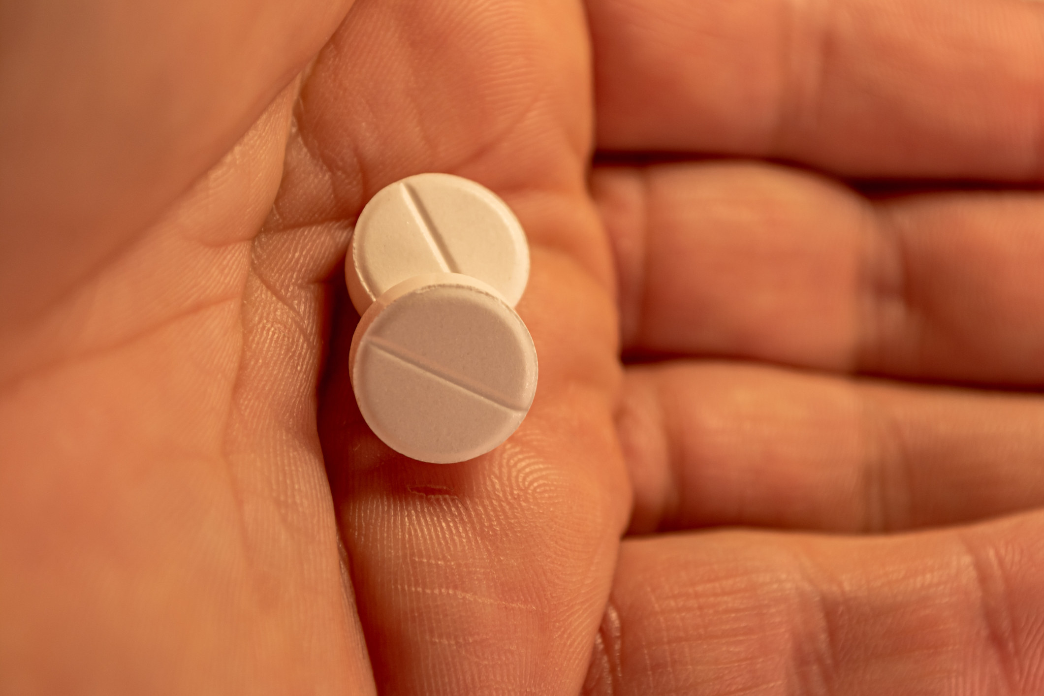 Stock image of a hand holding two pills