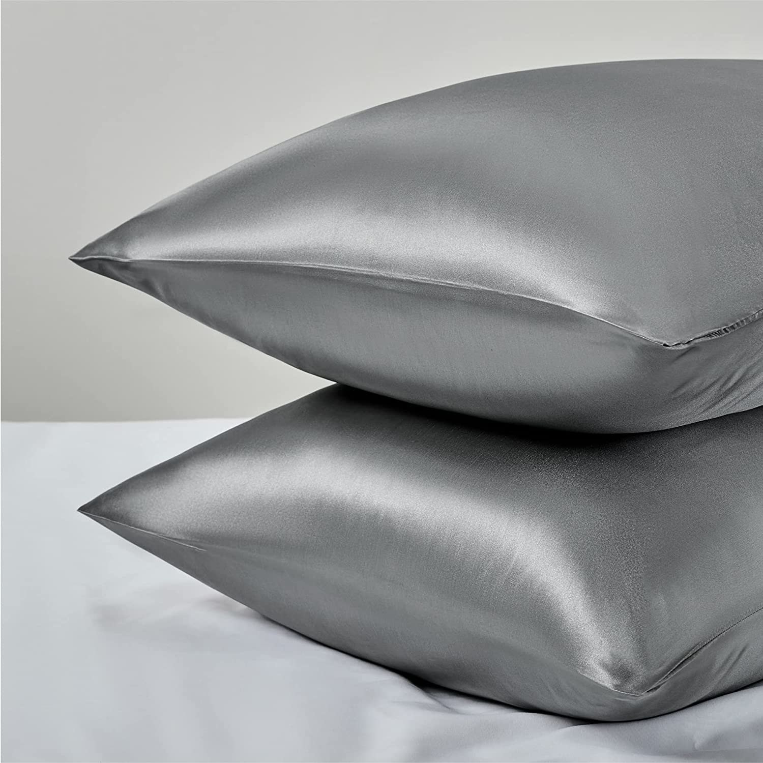 the gray satin pillowcases on two pillows