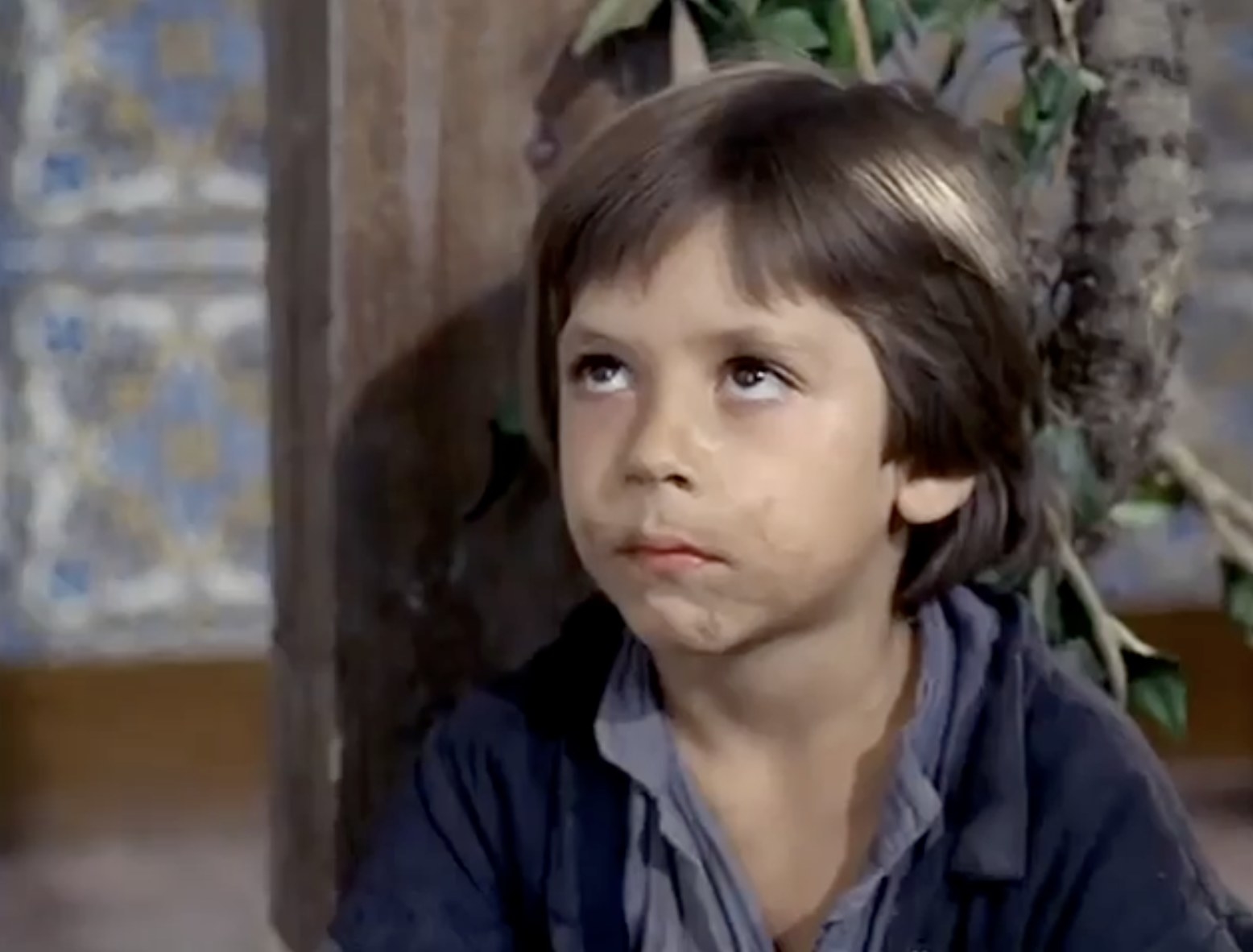 Javier Bardem as a little boy looking sad with dirt on his face