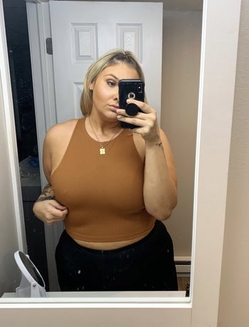 a reviewer wearing the top in burnt orange