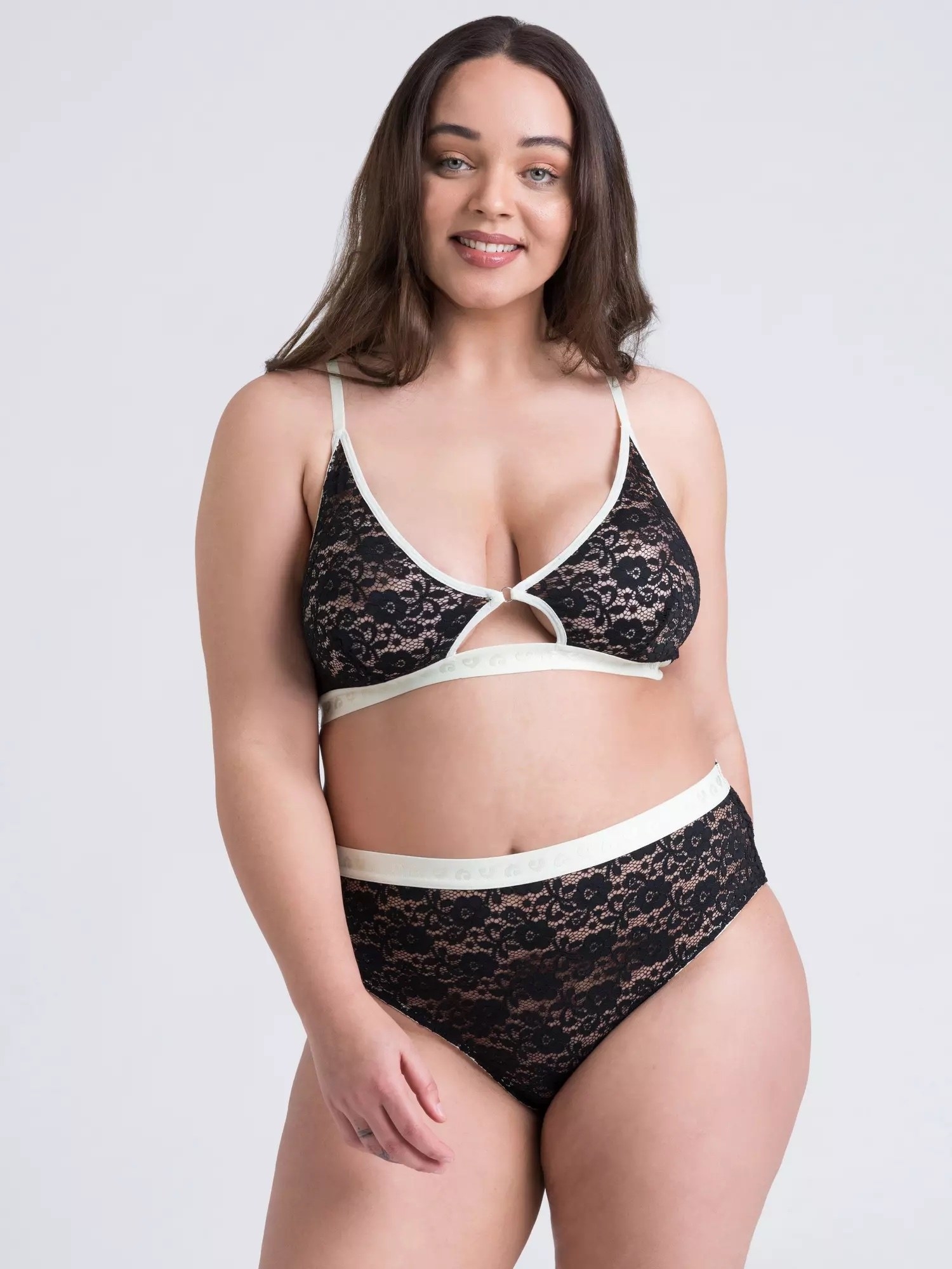 Model is wearing a black lace bra and underwear set with white borders around the hem