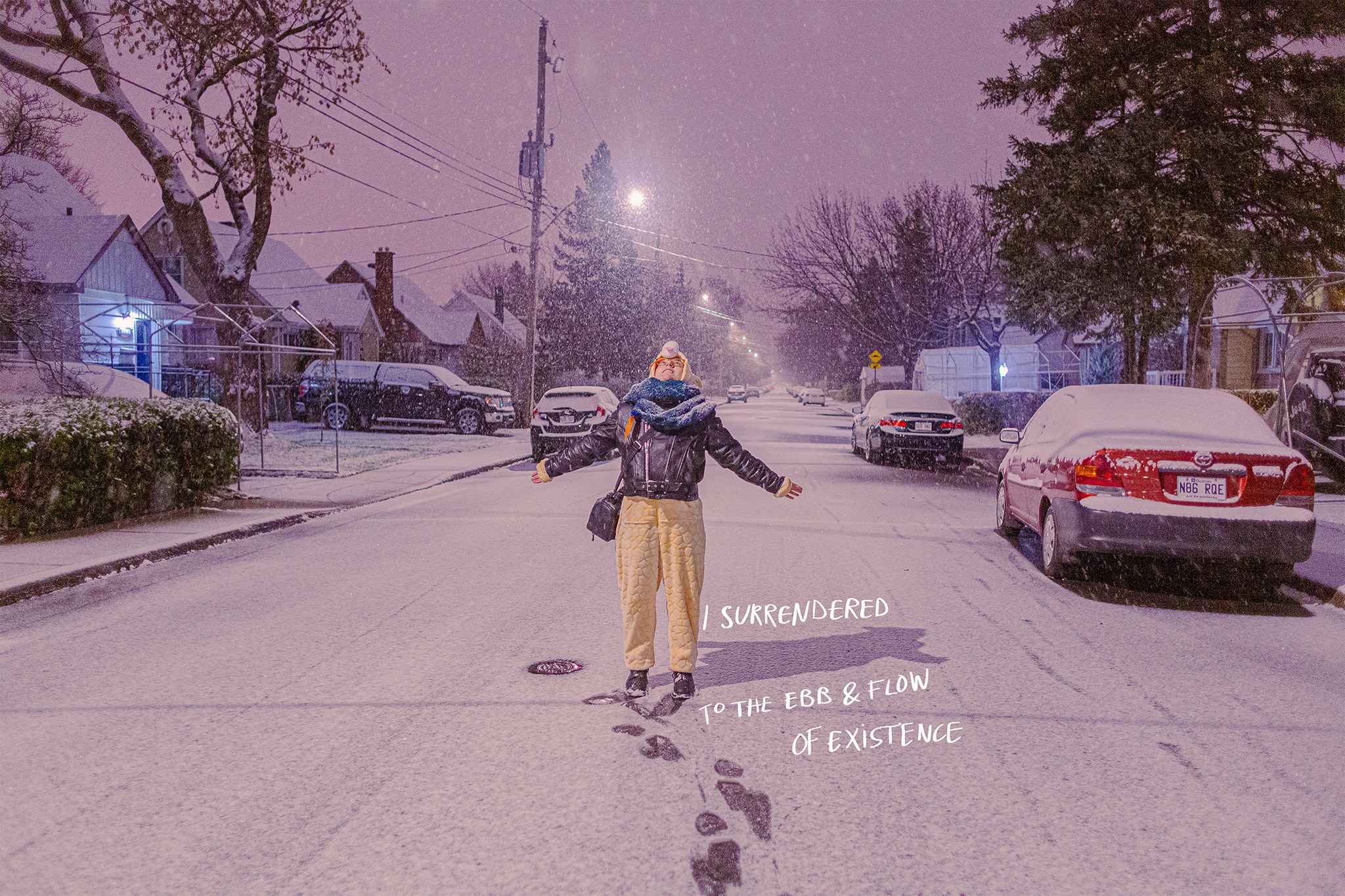 A person outside in the street in the snow with their arms wide with the text on the image reading, &quot;I surrendered to the ebb and flow of existence&quot;