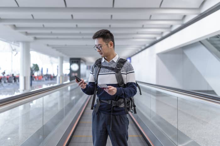 a man looking at his phone while going through the airport