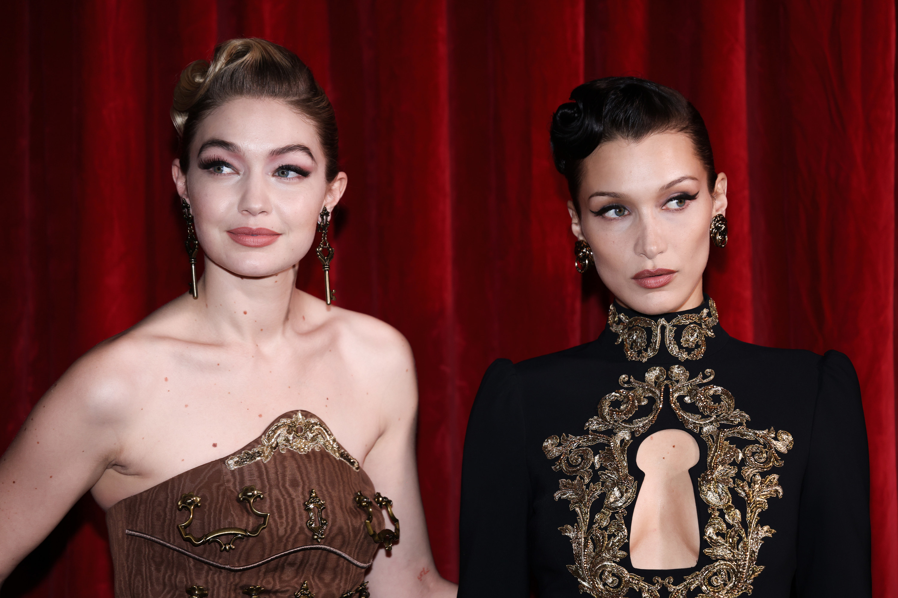 Gigi and Bella Hadid in evening gowns and large earrings with their hair styled up