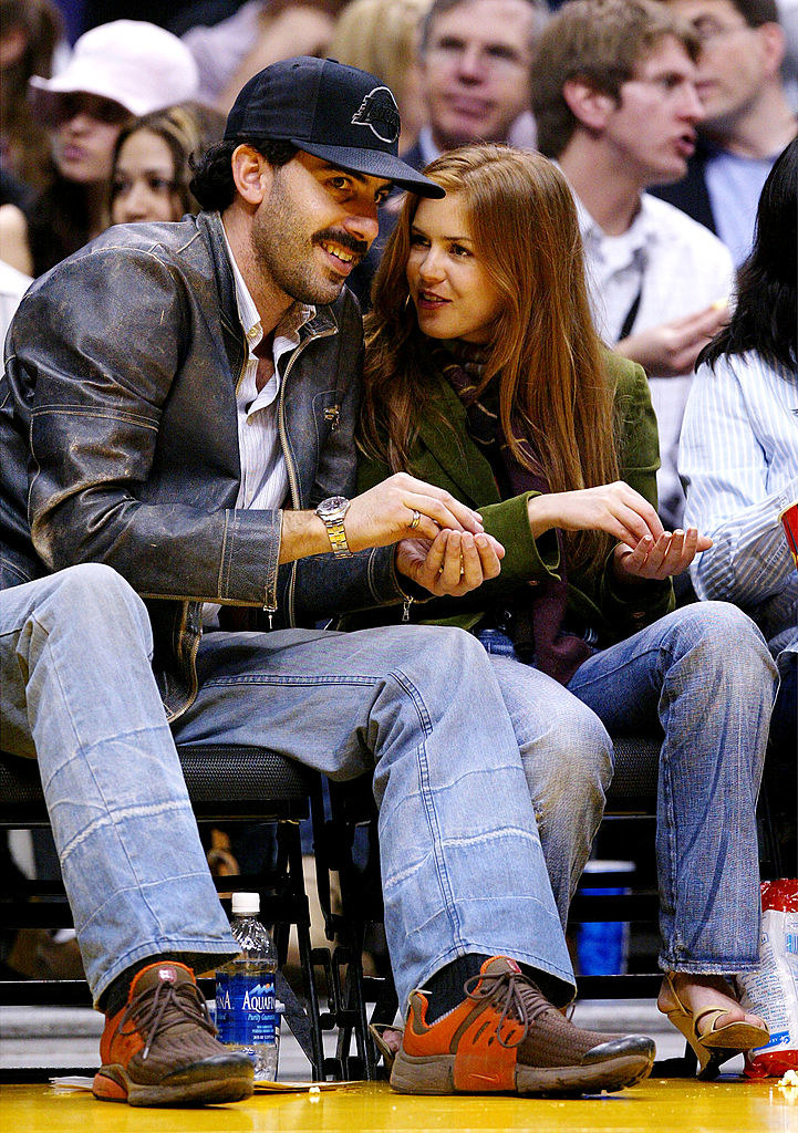 the couple chats at a basketball game