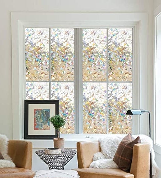 A set of windows covered with the rainbow film in a living room
