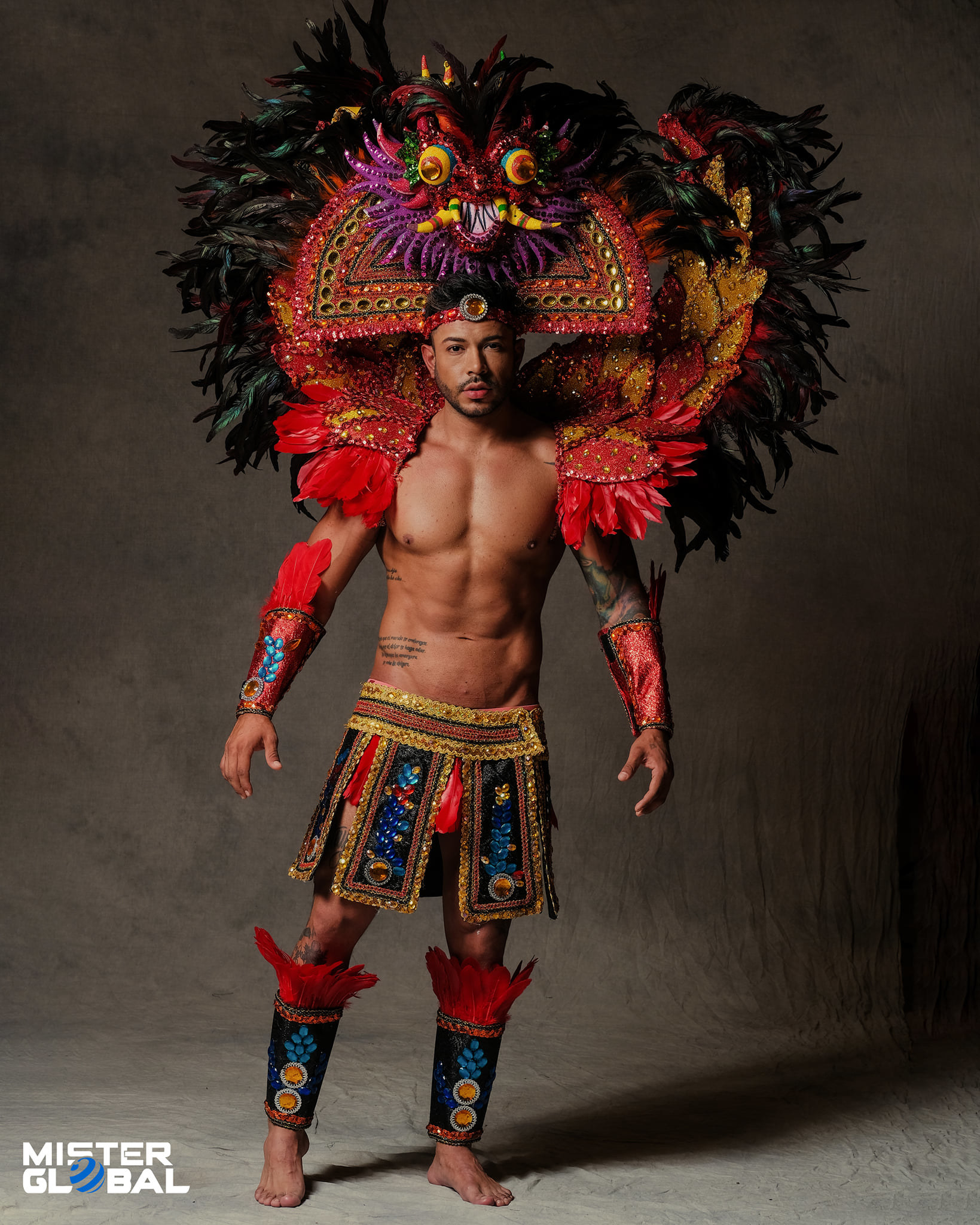 Bare-chested, barefoot man with large, ornate headdress and skirted, low-waisted, ornate loincloth