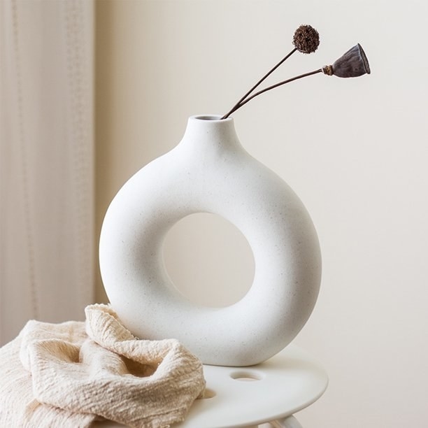 a hallowed out white ceramic vase on a table