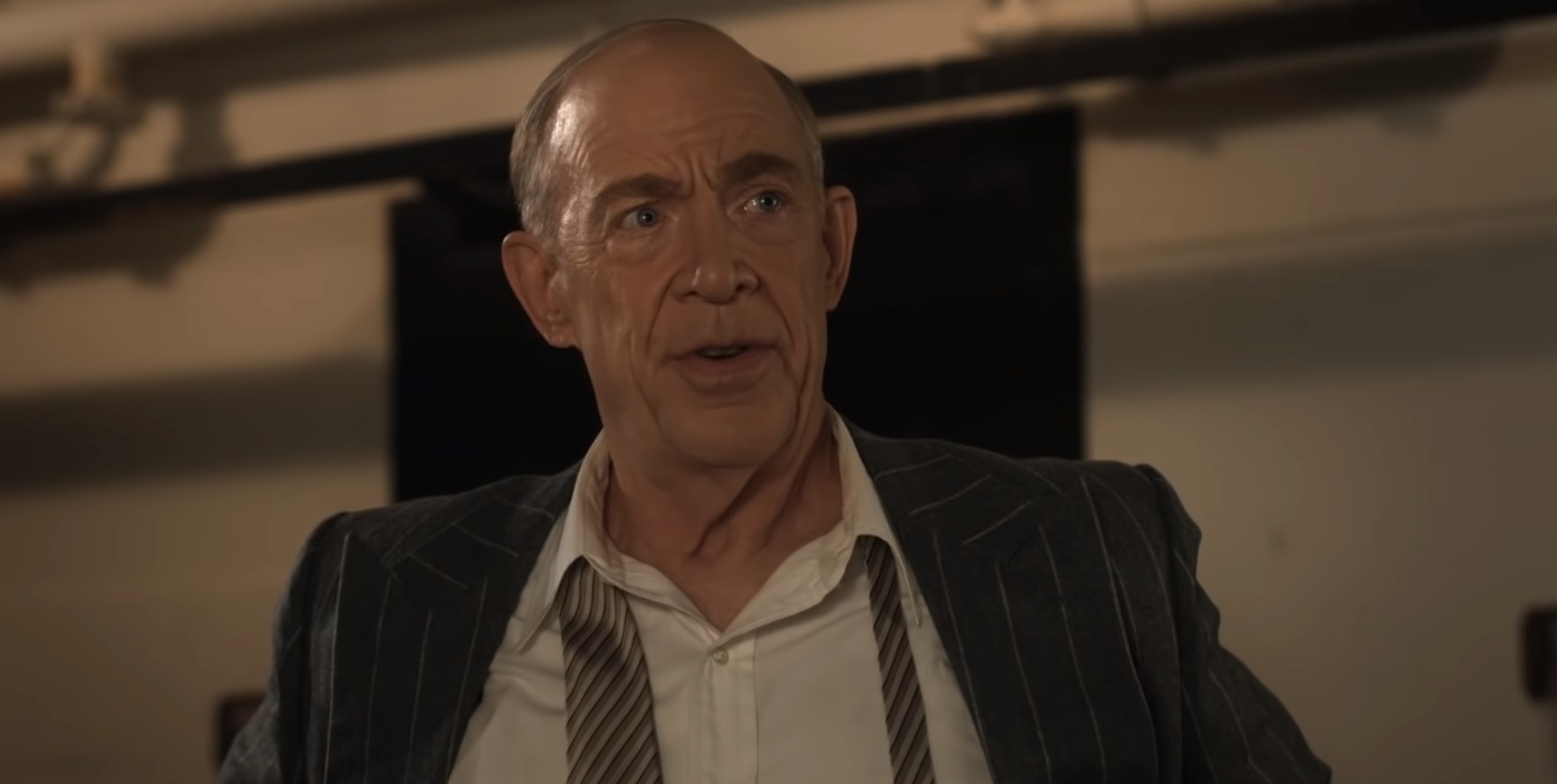 JK Simmons in a shirt, undone tie, and suit jacket