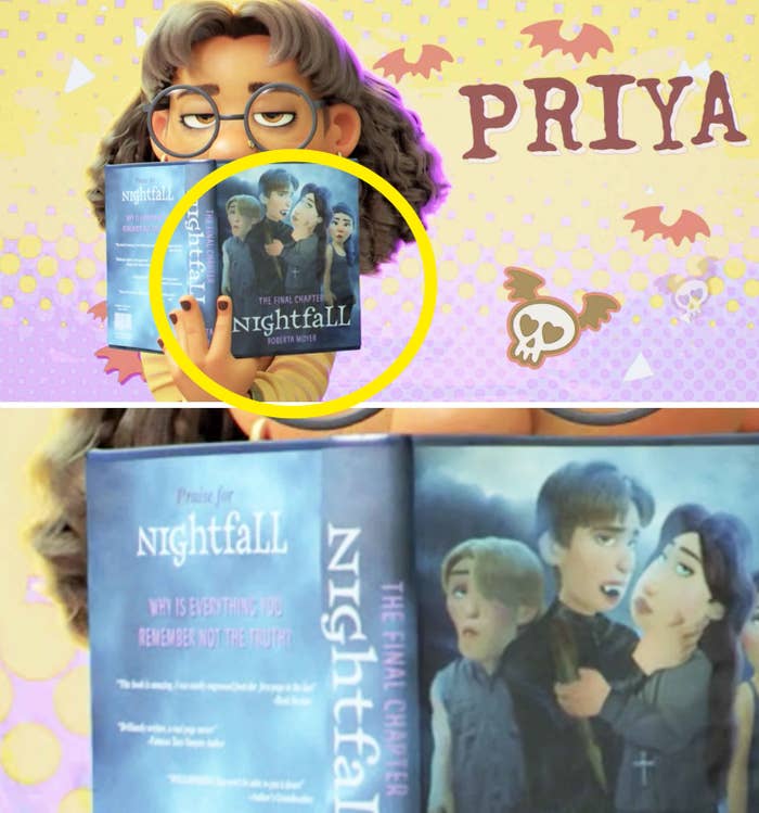 Priya holding up a book that features vampires on the cover