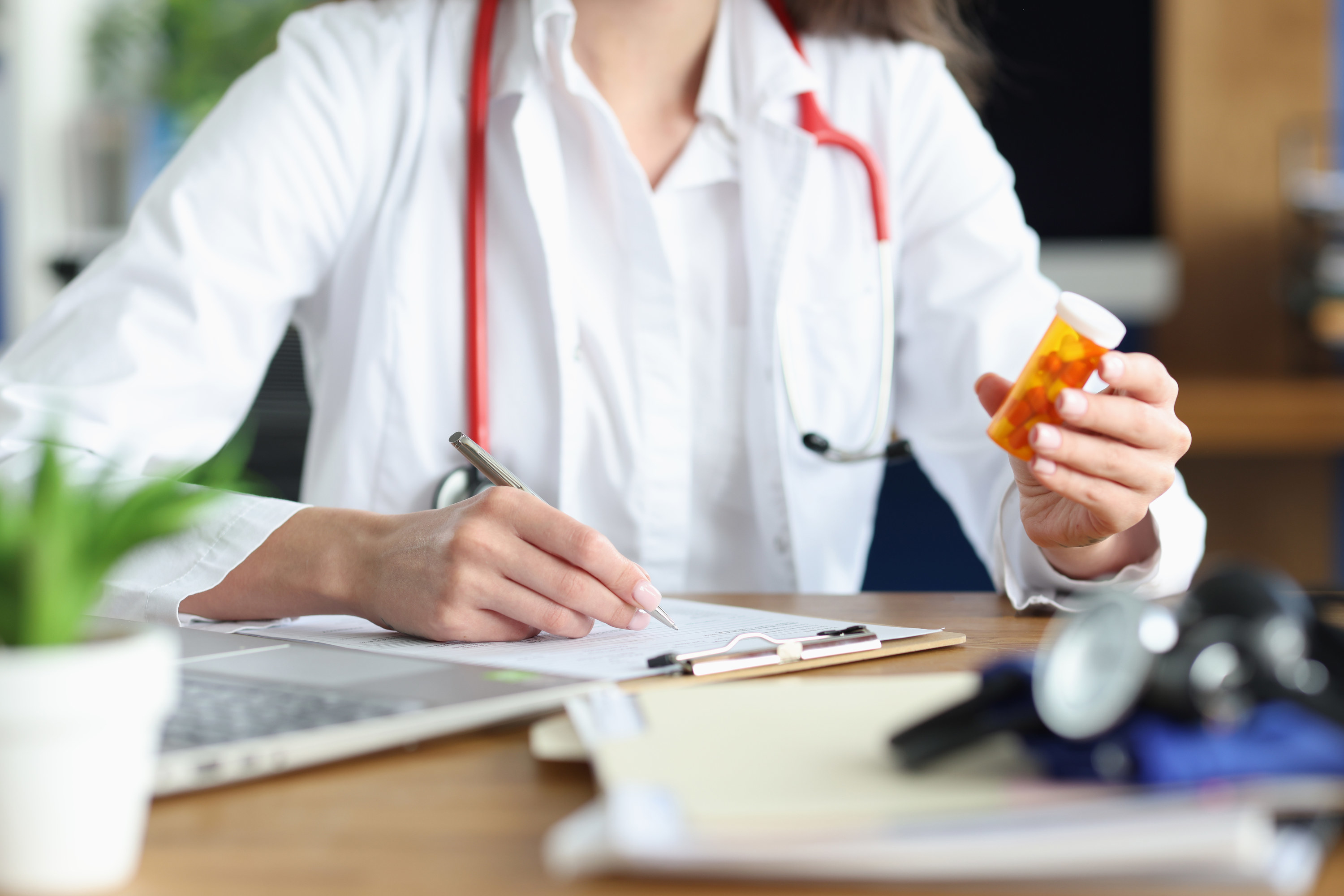 A doctor at her desk holding pills