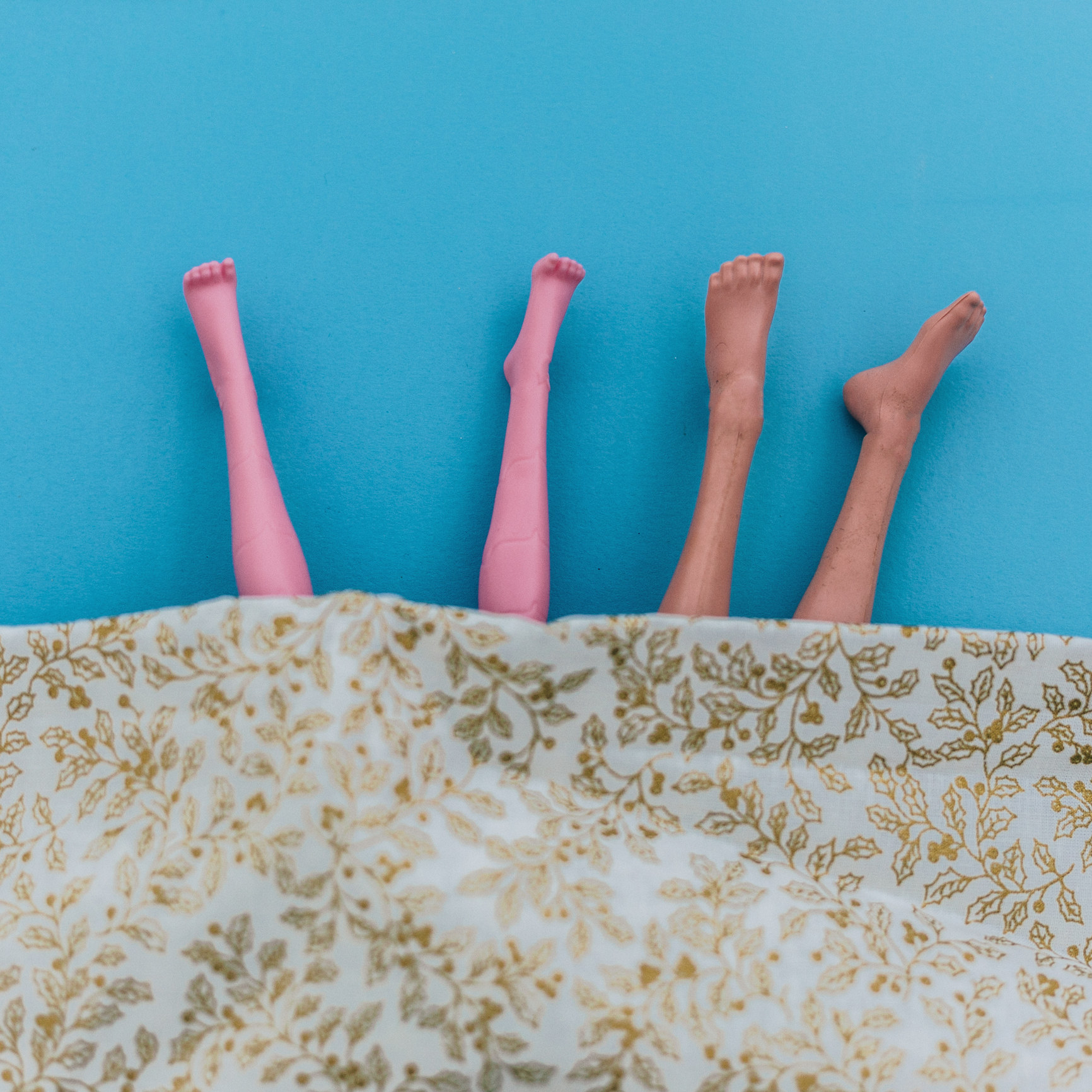 Stock image of barbie doll legs sticking out from under a blanket