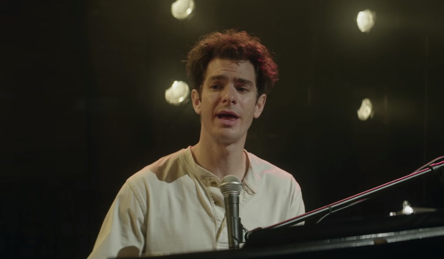 Andrew Garfield singing and playing the piano