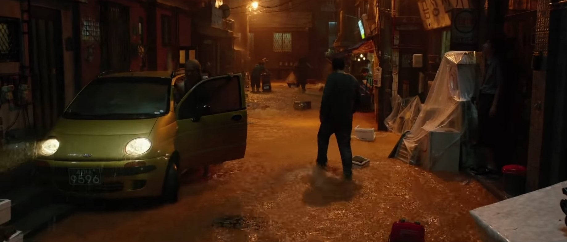 Ki-taek standing in a flooded street in "Parasite"