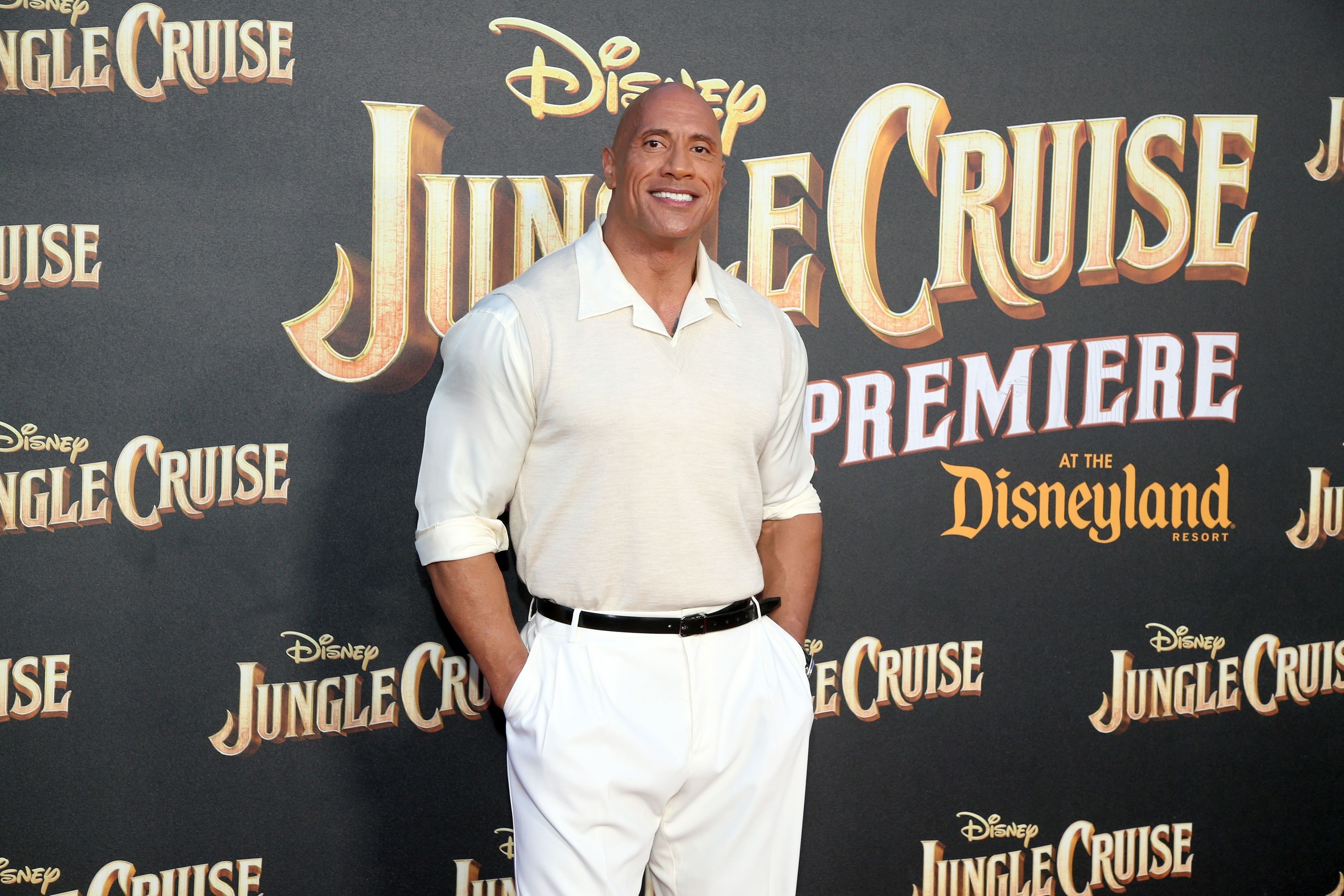 Dwayne poses with his hands in his pockets at a Jungle Cruise step-and-repeat