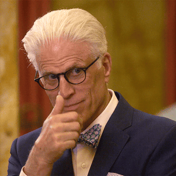 Ted Danson as Michael in The Good Place, giving a thumbs up and winking