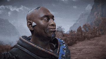 Sylens from &quot;Horizon Forbidden West&quot; played by Lance Reddick looking at the camera and tapping his head and smiling
