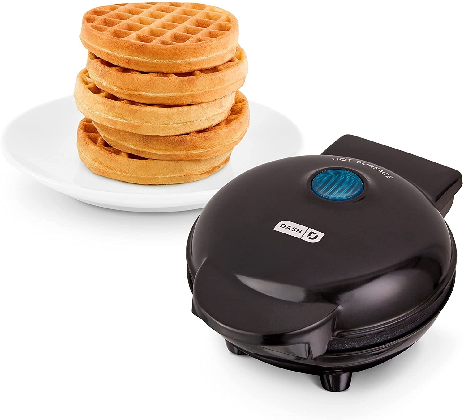 The waffle maker sitting next to a stack of waffles on a plate