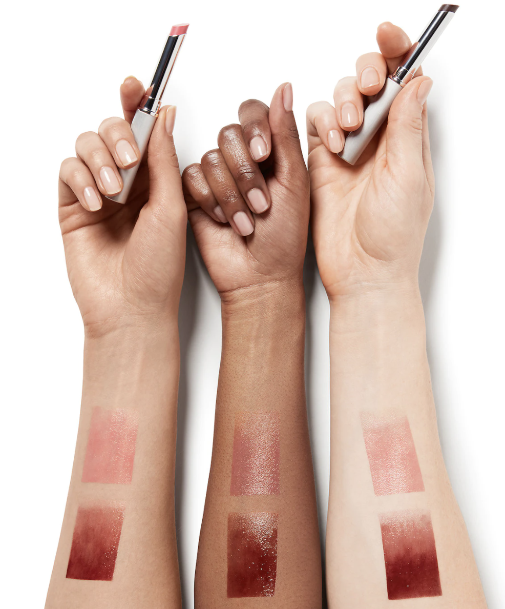 Three different arms with swatches of the lipstick demonstrating how they look on different skin tones