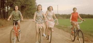 四个女孩骑着自行车上了一条土路