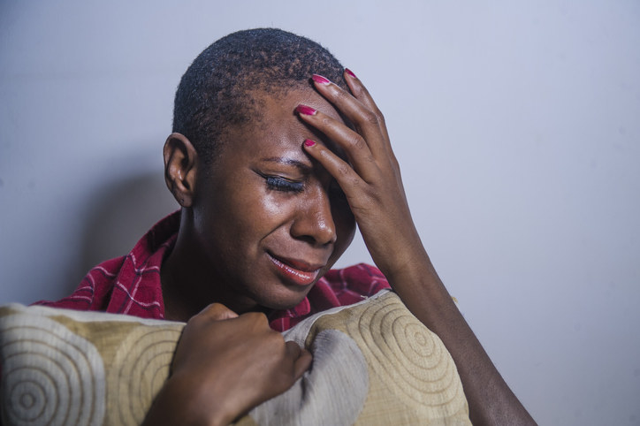 Person crying and holding their head