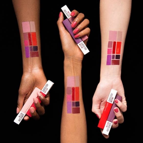 Models with red, purple and pink swatches of lip products on three different skin colors
