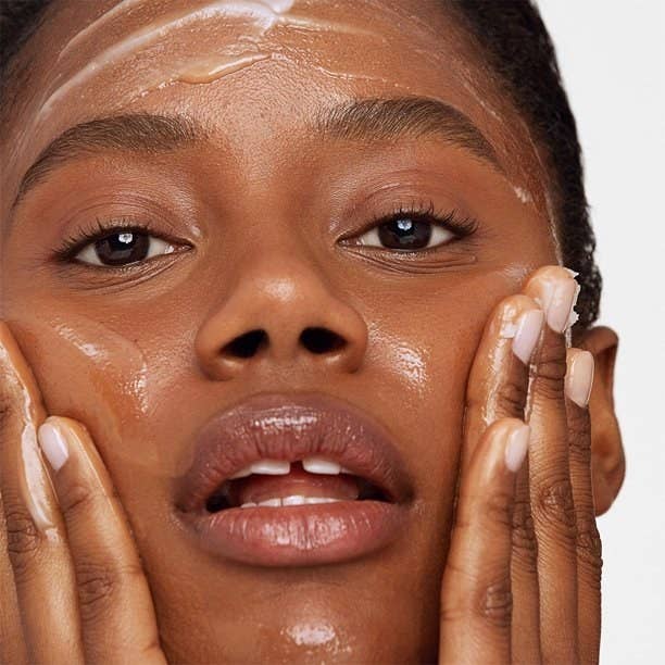 Model using cleansing balm on face