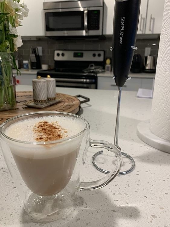 A latte with the frother next to it