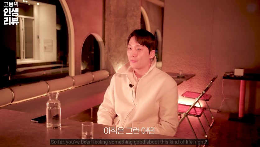 Se-hoon smiles in a dimly lit restaurant