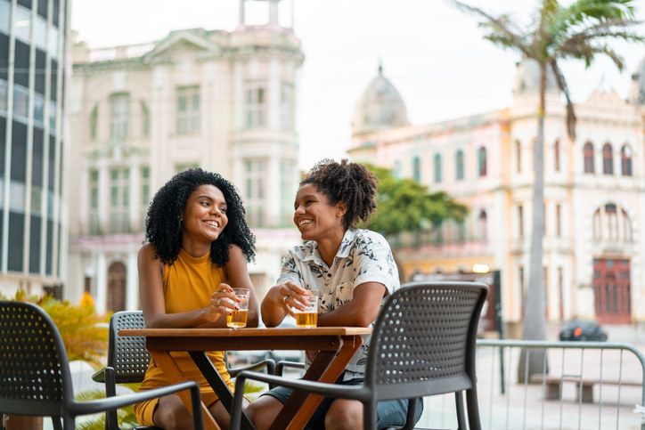 Queer couple sitting a restaurant on vacation