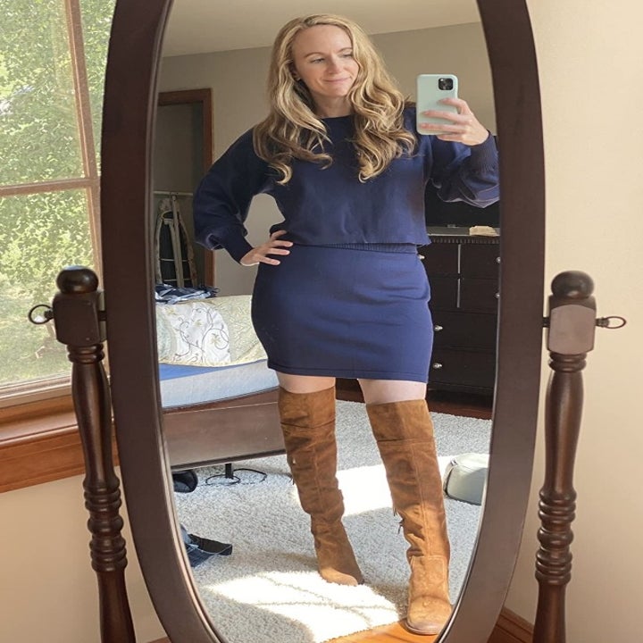 A reviewer wearing the same knit puff sleeve sweater and skirt co-ord set in navy